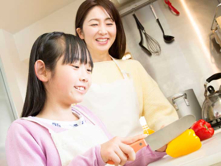 母親の料理の手伝いをしている女の子